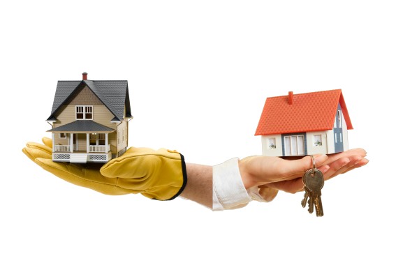A hand wearing builder gloves holding a house on the left, and hands holding a house and some keys on the right.